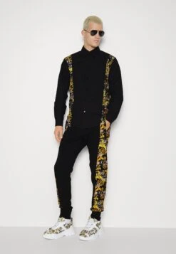 Versace Jeans CouturePRINT LOGO COUTURE - Träningsbyxor - Black/gold -Stil och Komfort Butik 0cc4233971404f229a361d951a15c484