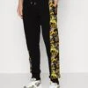 Versace Jeans CouturePRINT LOGO COUTURE - Träningsbyxor - Black/gold -Stil och Komfort Butik 0e36041f1bd647b3b5d21ff9902ef039